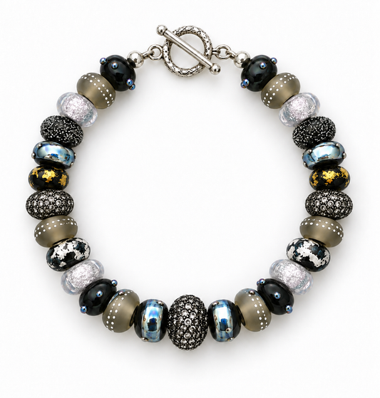 Silver Smoke beaded bracelet arranged in a circle on white, showing patterned black and gray beads, metallic accents and a silver-tone toggle clasp | Bliss by Cori
