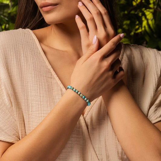Karma and Luck Divine Healing Turquoise Evil Eye Bracelet worn on wrist — earthy teal turquoise jasper beads with teal evil eye charm, lifestyle shot | Bliss by Cori
