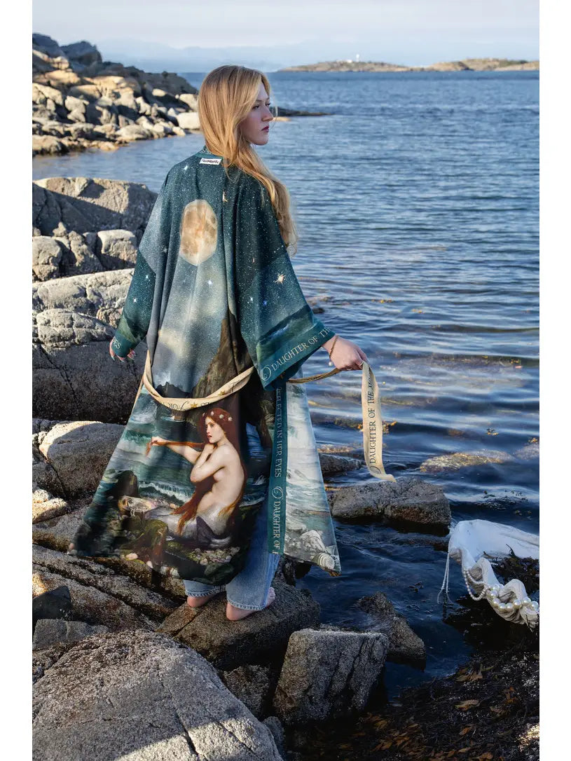 Side-back view of the Siren mermaid duster flowing over rocks beside the water | Bliss by Cori