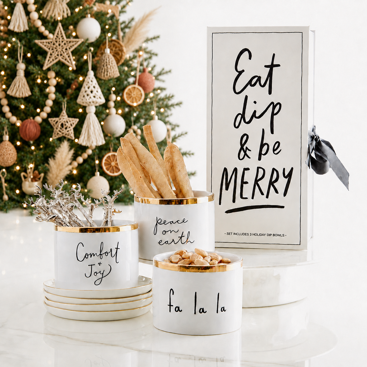 Eat Dip & Be Merry gold holiday dip bowls styled with breadsticks, silver reindeer picks and snacks beside the white keepsake book box gift set – Bliss by Cori
