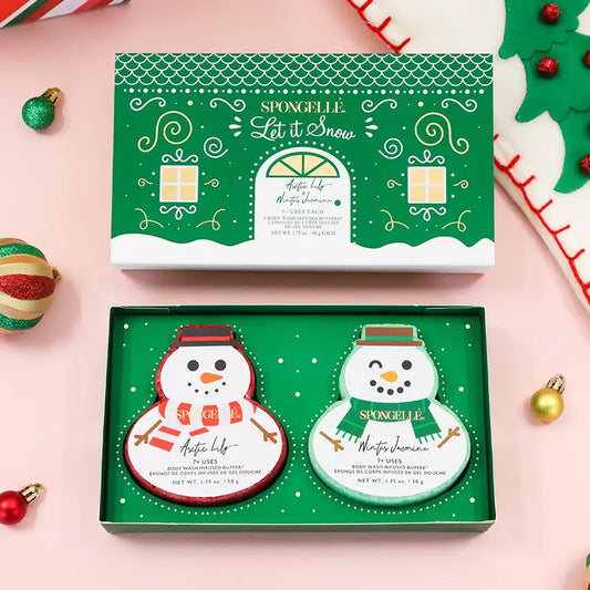 Spongellé Let It Snow gift set open box with snowman buffers on pink holiday background with colorful ornaments — Bliss by Cori Boutique