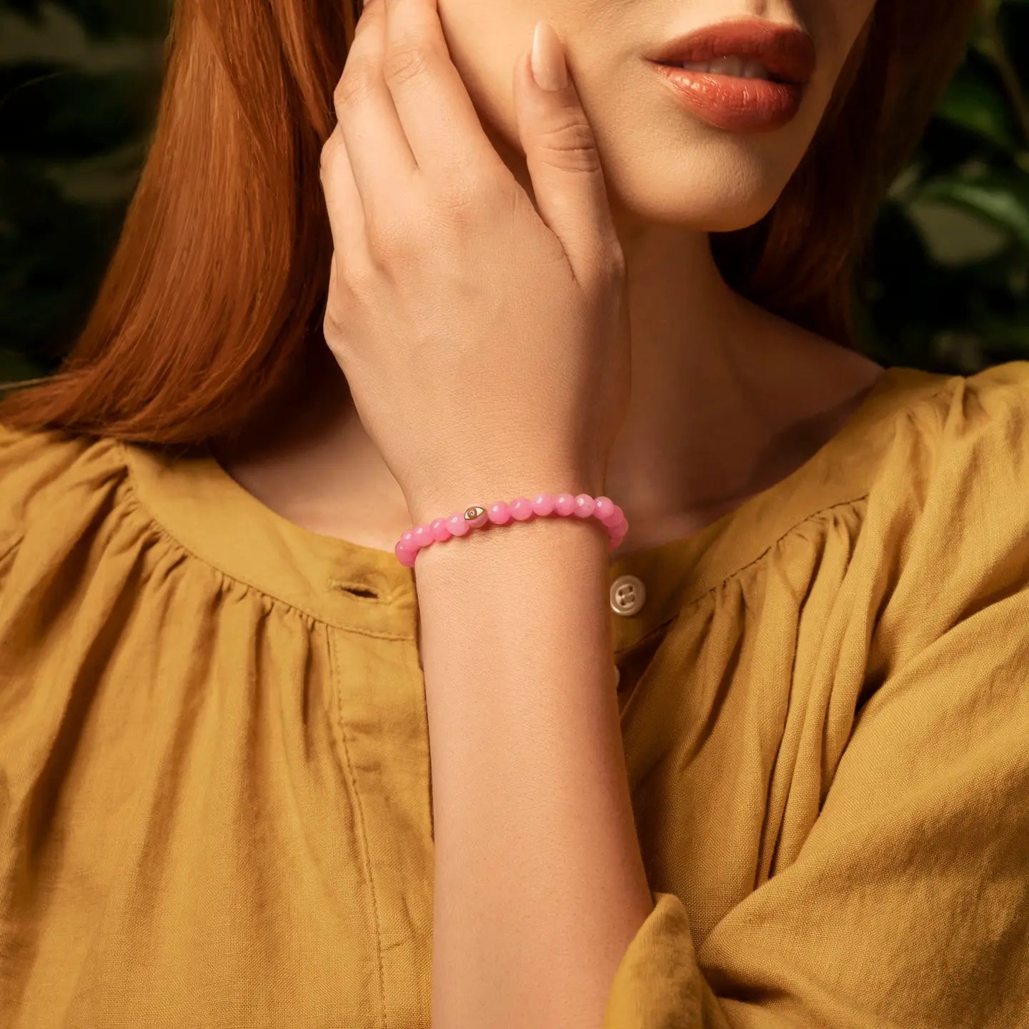 Karma and Luck Genuine Peace Pink Tourmaline Evil Eye Bracelet worn on wrist — soft blush-pink tourmaline beads with pink and gold evil eye charm, lifestyle shot | Bliss by Cori