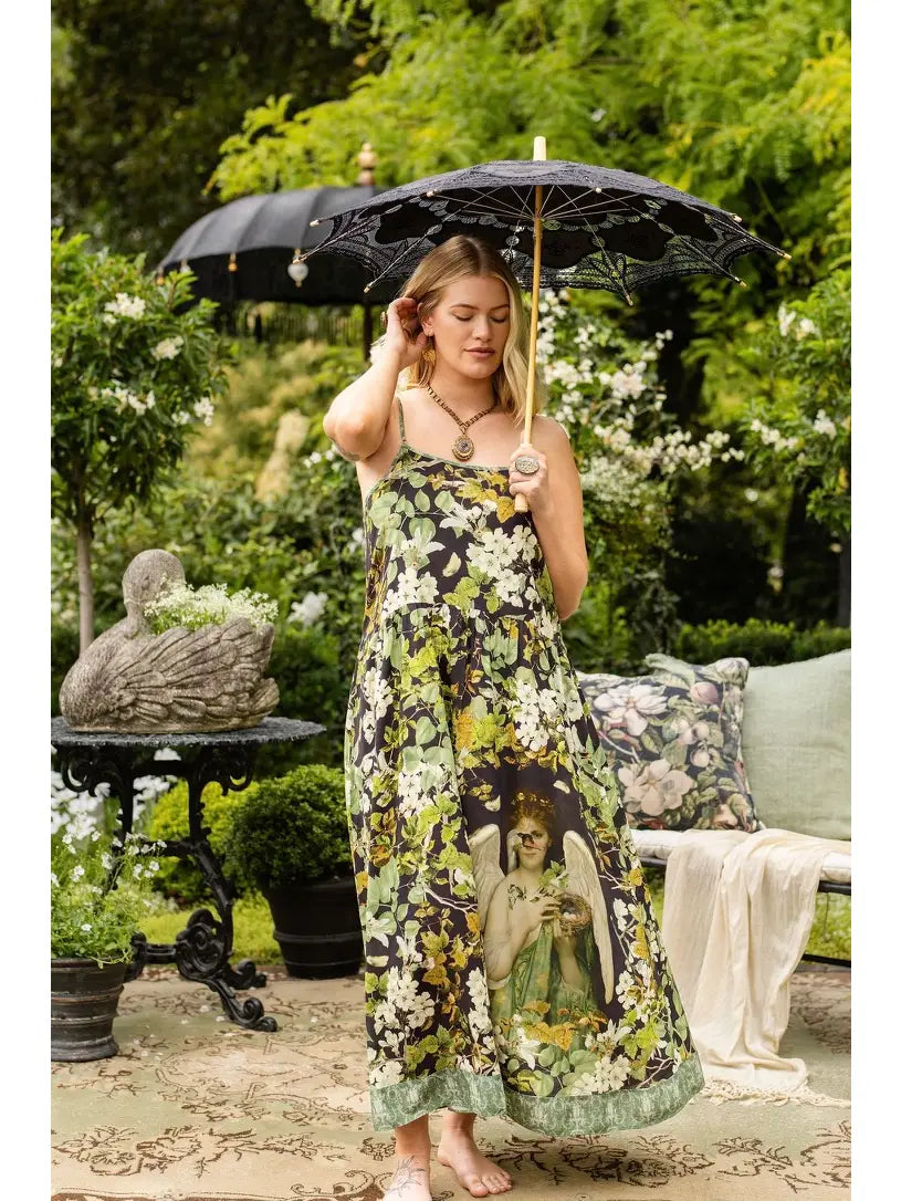 Model wearing the Equinox swan botanical maxi dress with a black parasol in a garden | Bliss by Cori