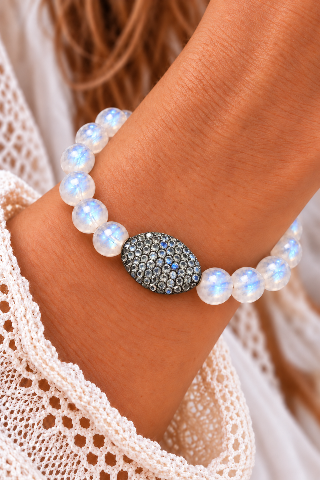 Rainbow Moonstone beaded bracelet with an oval pavé accent worn on a wrist beside a white lace sleeve | Bliss by Cori