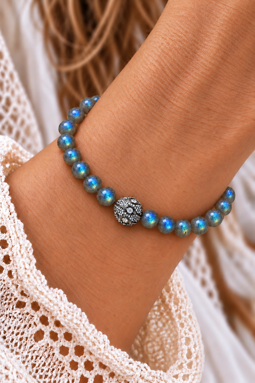 Labradorite bracelet with blue-green beads and a Polki Diamond accent worn on a wrist beside white lace | Bliss by Cori
