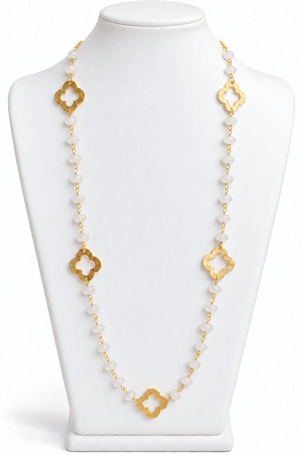 Milky white moonstone bead necklace with gold open quatrefoil clover accents displayed on a white jewelry bust | Bliss by Cori