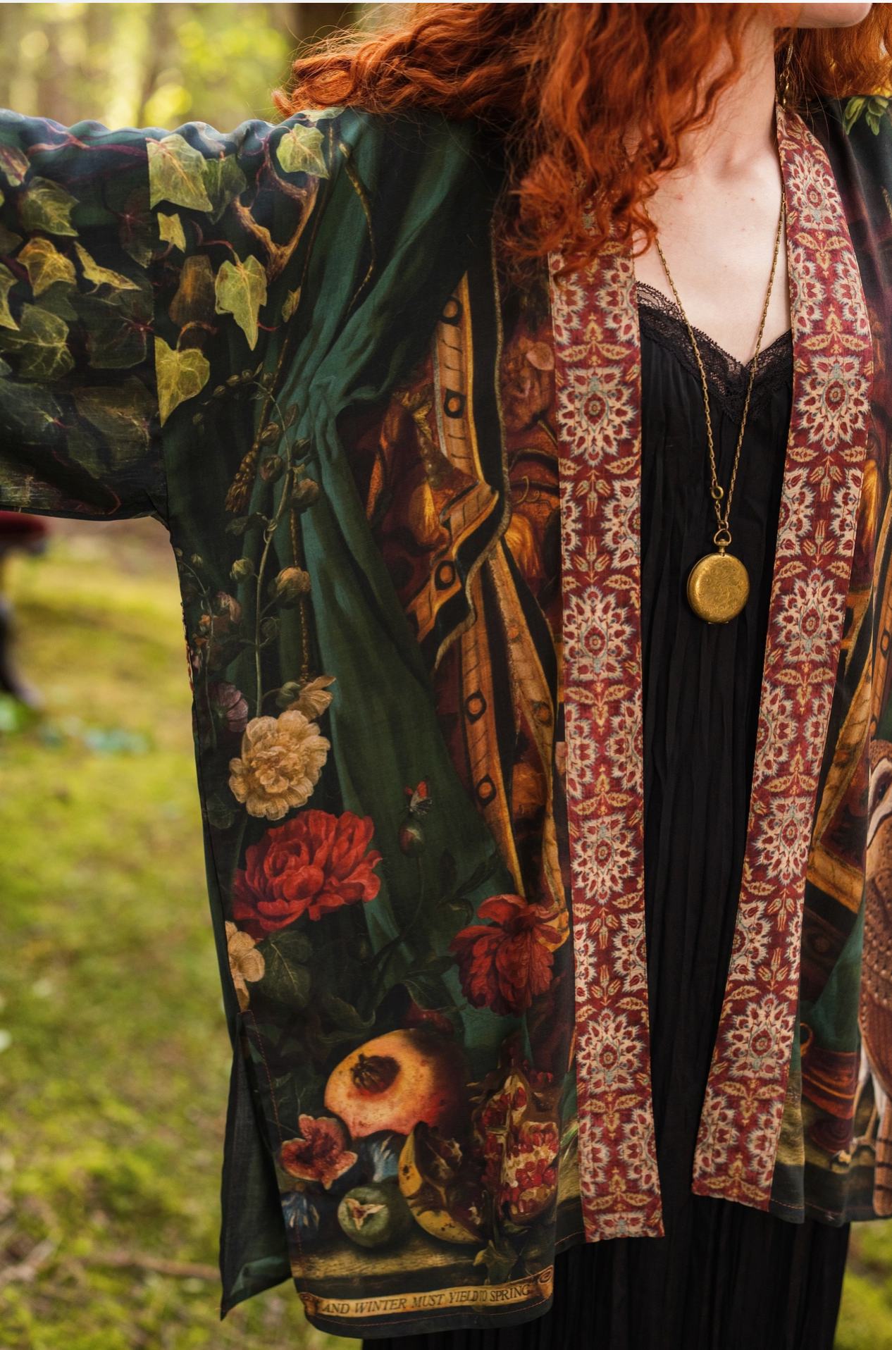 Close-up of Solstice Matinée Mid-Length Duster Kimono showing moon, stars and botanical ivy print with Proserpine portrait detail on dark green viscose fabric — Bliss by Cori