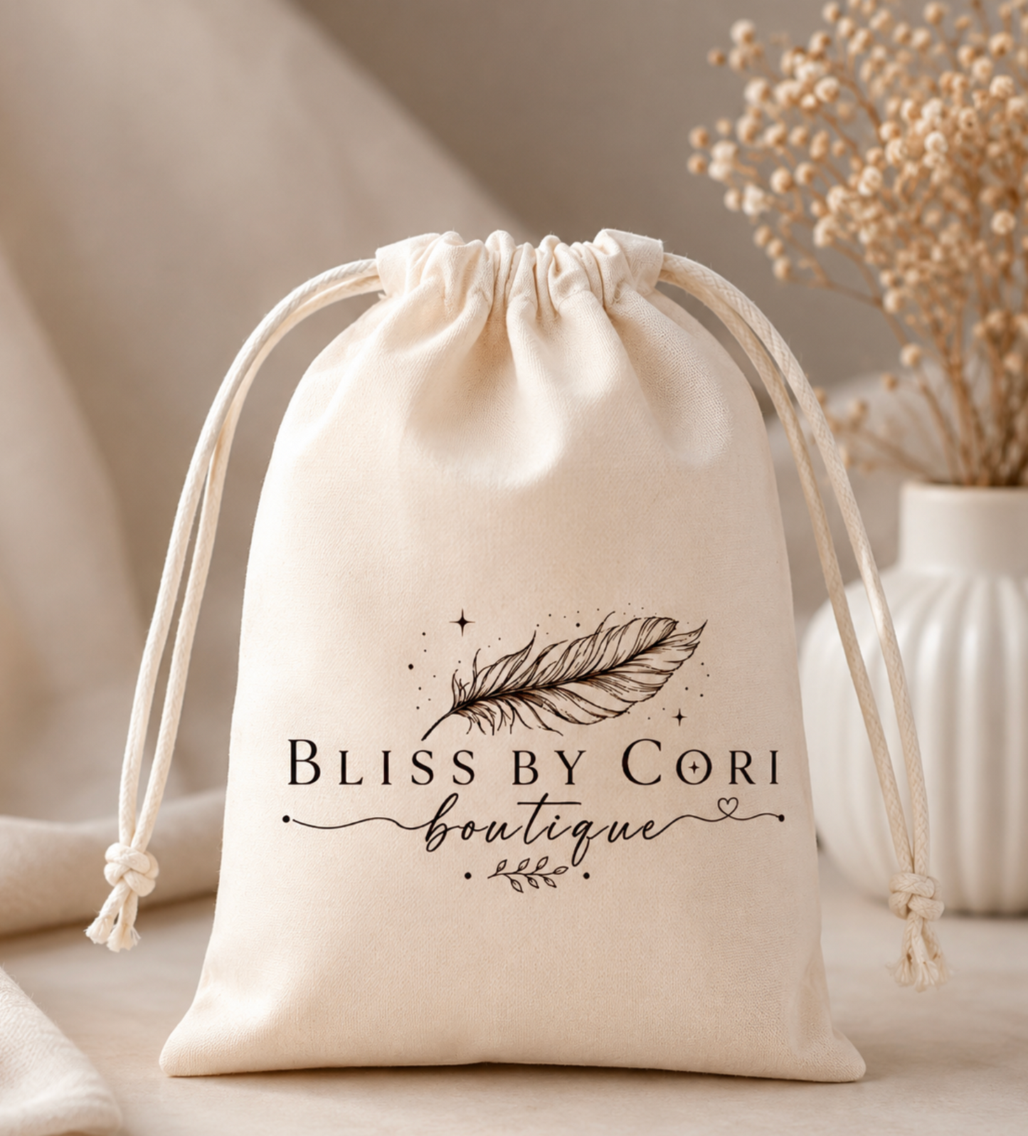 Cream drawstring jewelry gift pouch with Bliss by Cori Boutique feather logo – included with every jewelry purchase