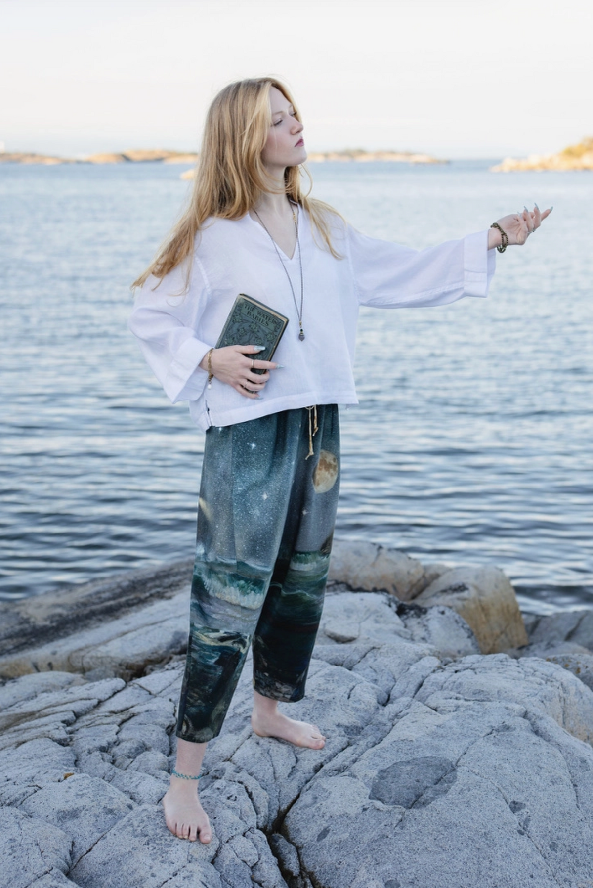 Back view of the Siren cropped pants with arms extended beside the sea | Bliss by Cori
