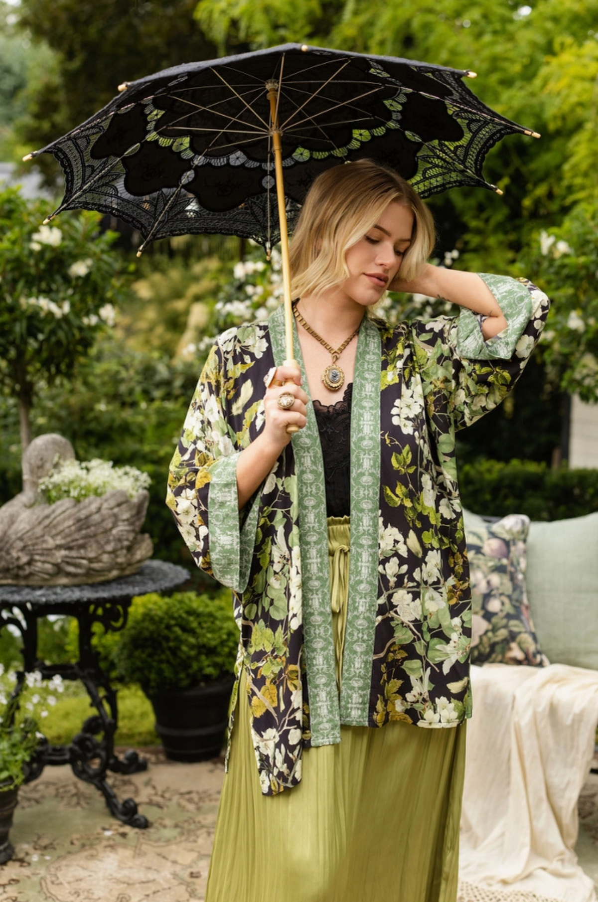 Model styling the Equinox botanical duster with a black parasol and sage green dress | Bliss by Cori