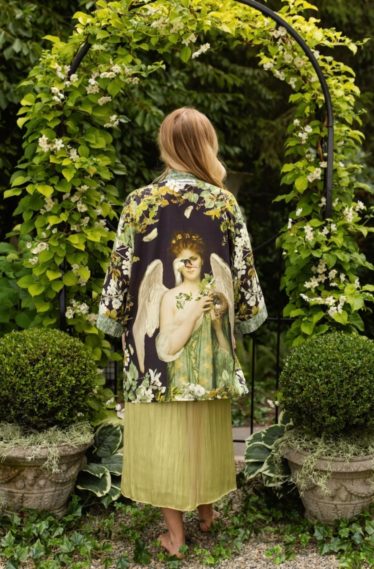 Model wearing the Market of Stars Equinox botanical duster over a sage green dress in a garden | Bliss by Cori