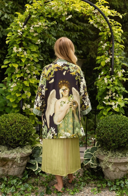 Model wearing the Market of Stars Equinox botanical duster over a sage green dress in a garden | Bliss by Cori