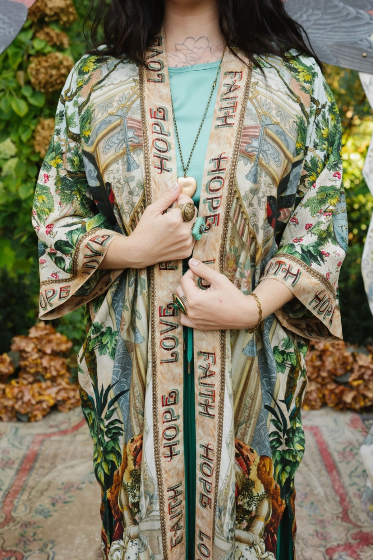 Close-up of Book of Love duster showing Faith Hope Love trim, botanical artwork, and wide sleeves | Bliss by Cori