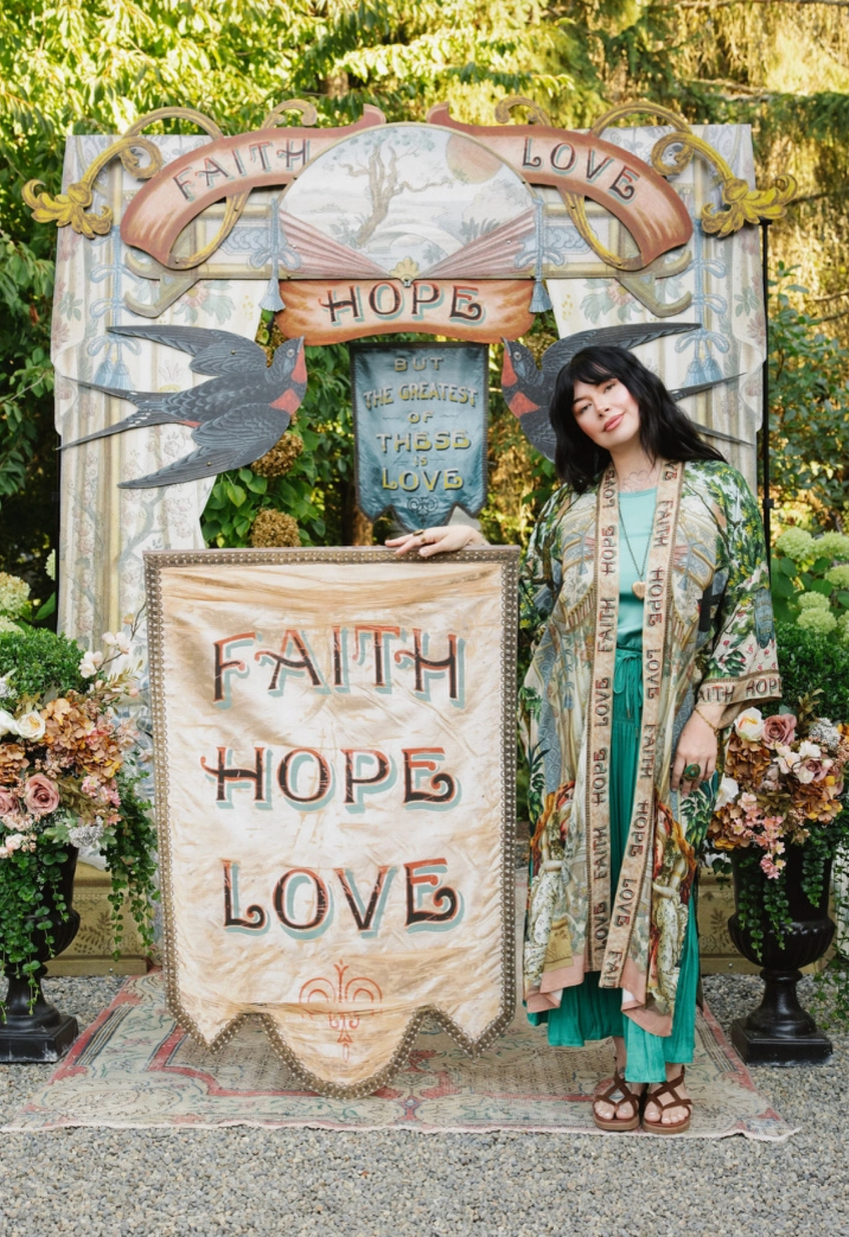 Model wearing Book of Love duster over a turquoise dress beside a Faith Hope Love banner | Bliss by Cori