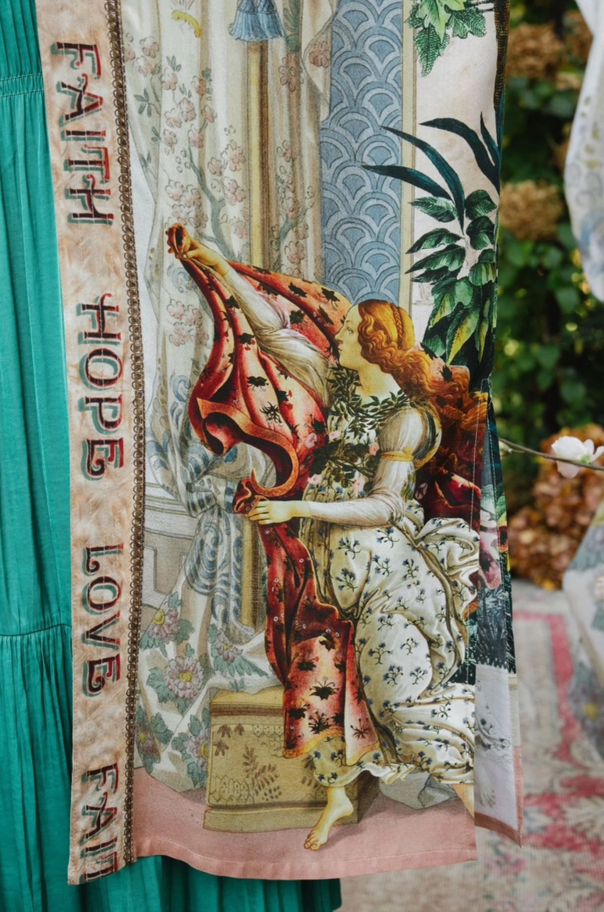 Close-up of Book of Love duster showing a vintage figure holding red drapery beside Faith Hope Love trim | Bliss by Cori