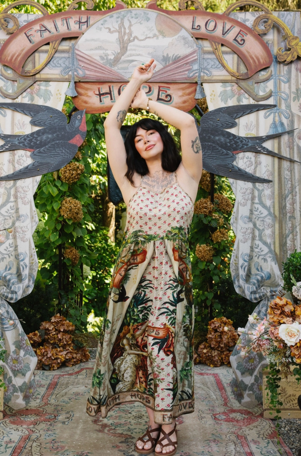 Model wearing Book of Love maxi slip dress with floral bodice and illustrated skirt, arms raised | Bliss by Cori