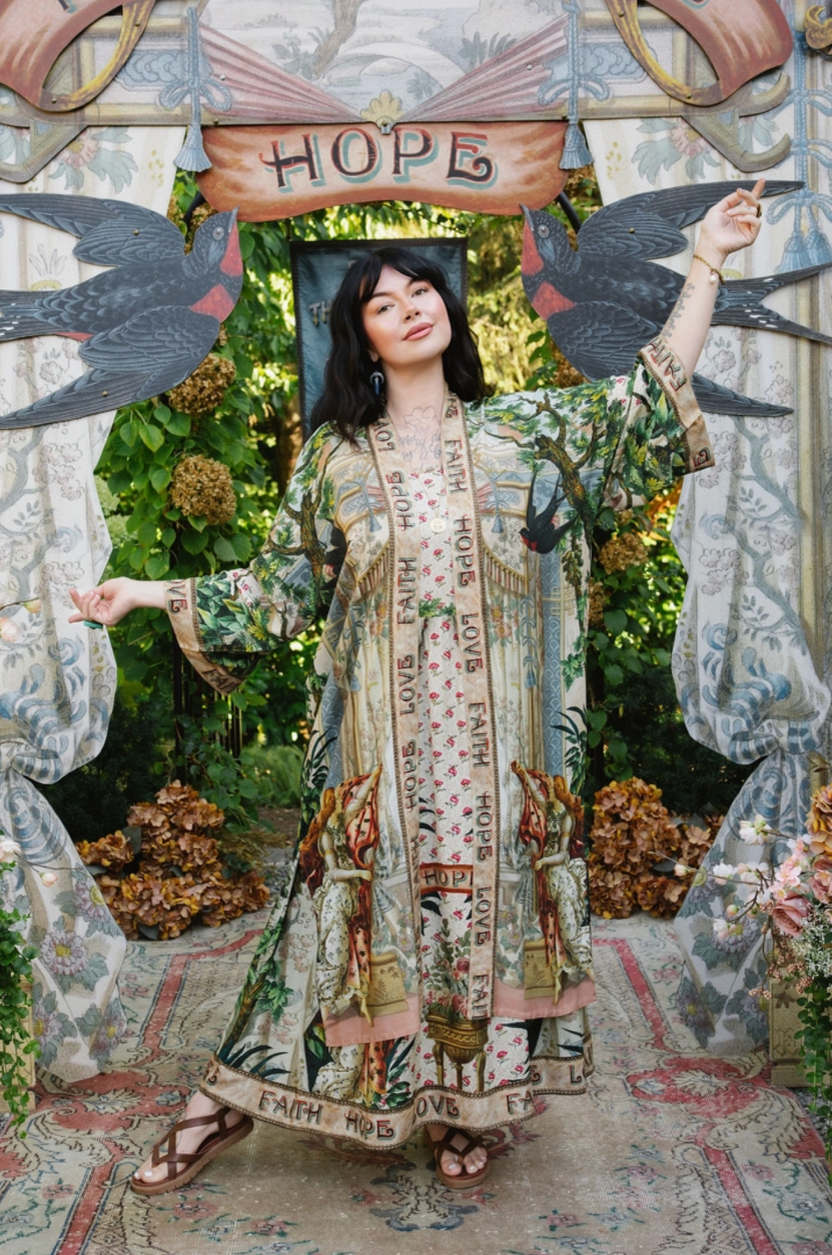 Book of Love maxi dress layered with a matching open duster, showing floral bodice and lettered skirt hem | Bliss by Cori