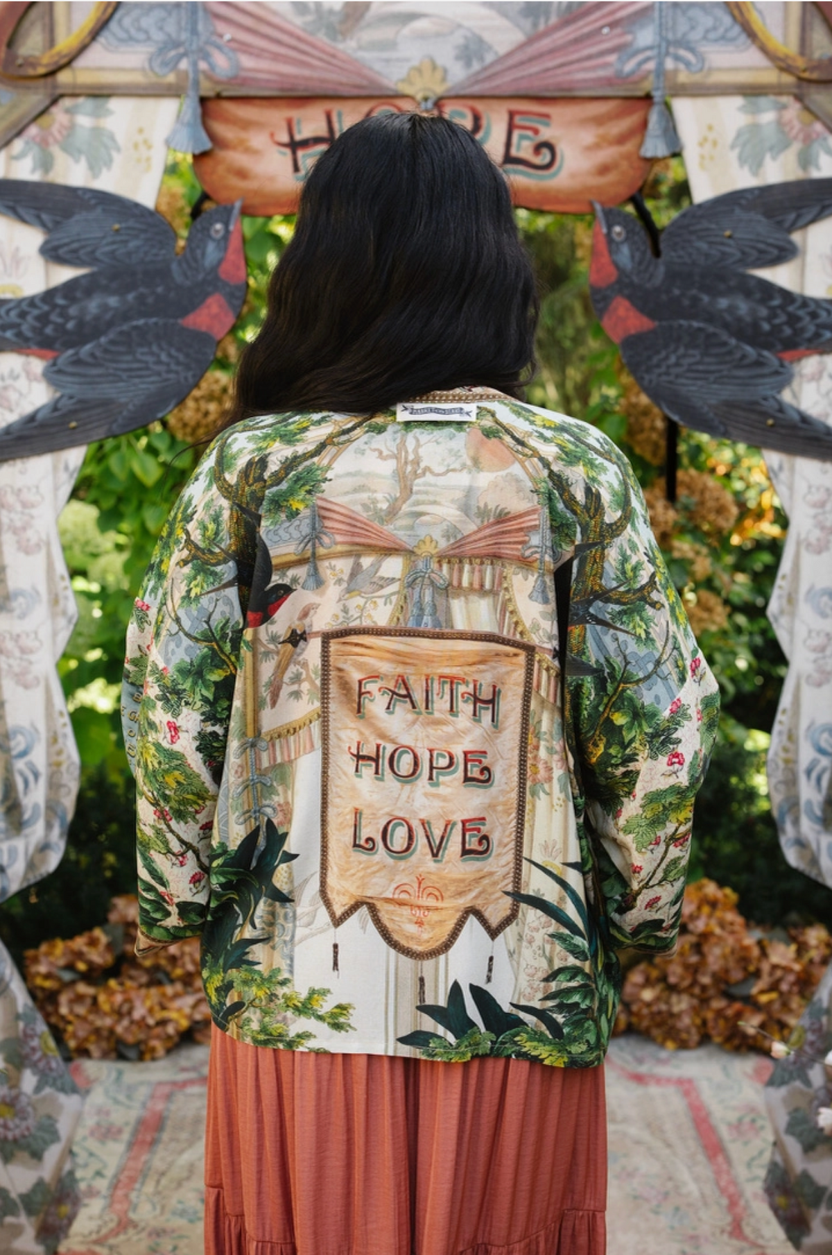 Back view of Book of Love cropped kimono showing the Faith Hope Love banner, swallows, and green foliage | Bliss by Cori