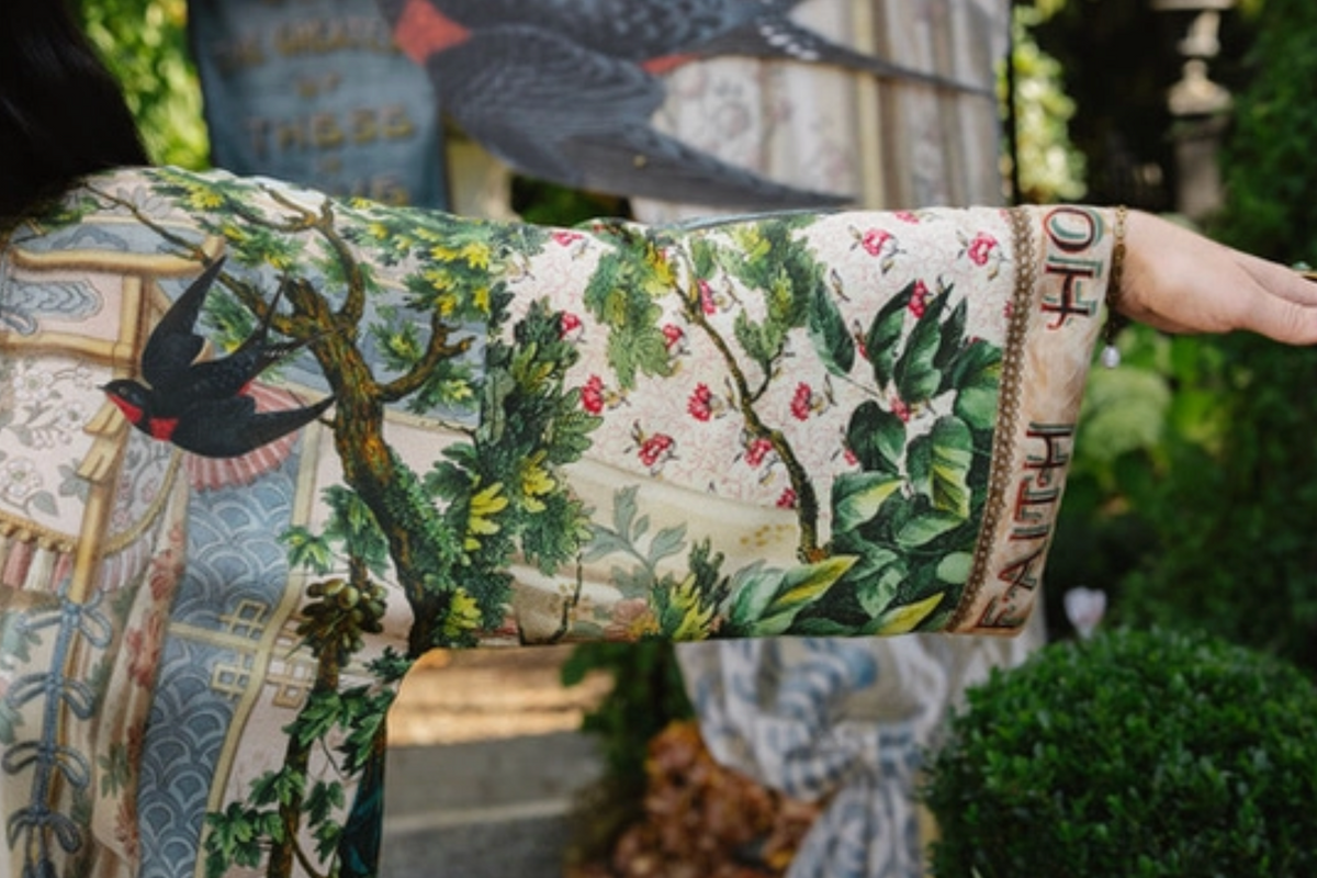 Book of Love kimono sleeve showing a black swallow, leafy branches, pink flowers, and lettered cuff | Bliss by Cori