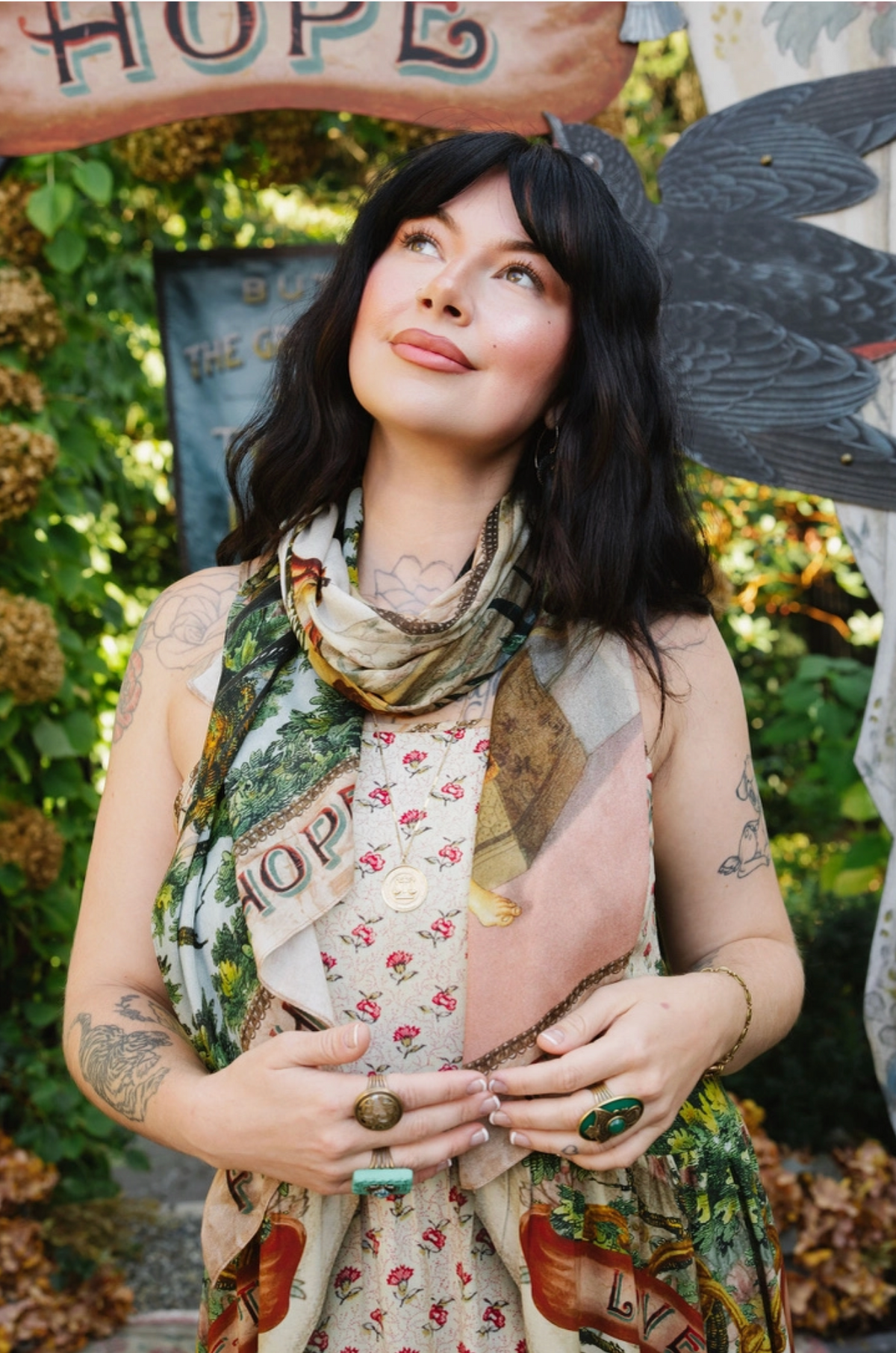 Close-up of Book of Love scarf wrapped around the neck, showing botanical artwork, pink accents, and lettered border | Bliss by Cori