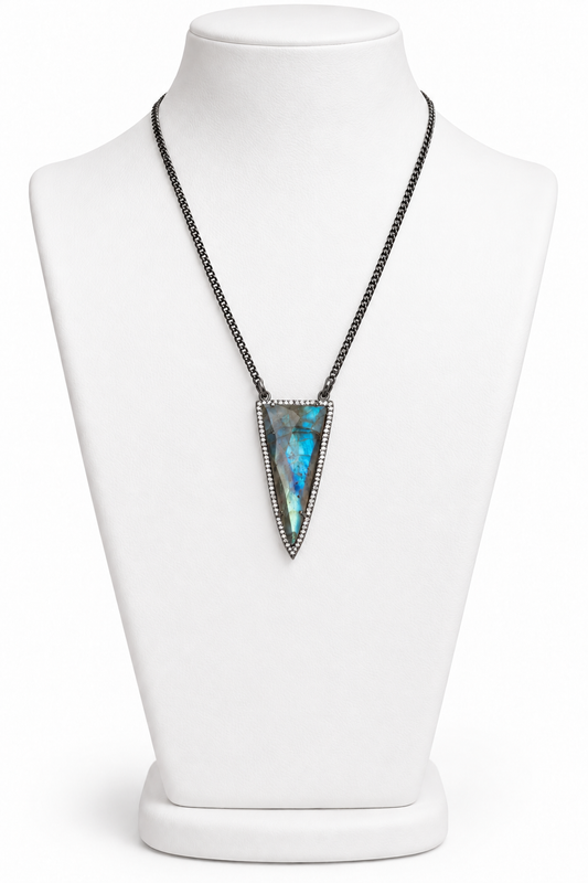 Labradorite point pendant with blue-green flash, cubic zirconia border, and dark chain displayed on a white jewelry bust | Bliss by Cori