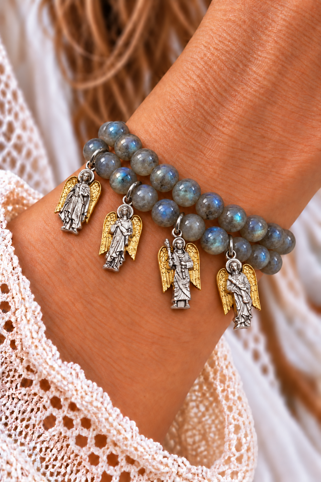 Two labradorite bead bracelets with four silver-tone archangel charms and gold-tone wings worn on a wrist | Bliss by Cori