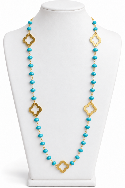 Turquoise faceted bead necklace with gold open quatrefoil clover accents on a white jewelry bust | Bliss by Cori