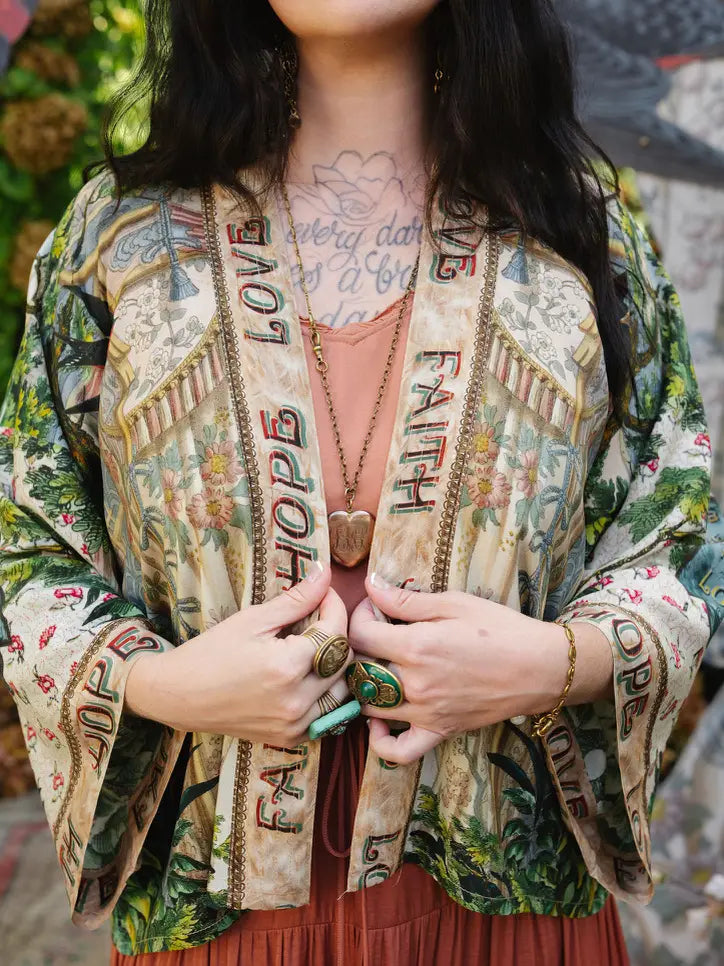 Close-up of Book of Love cropped kimono showing Faith Hope Love front trim, botanical artwork, and wide cuffs | Bliss by Cori