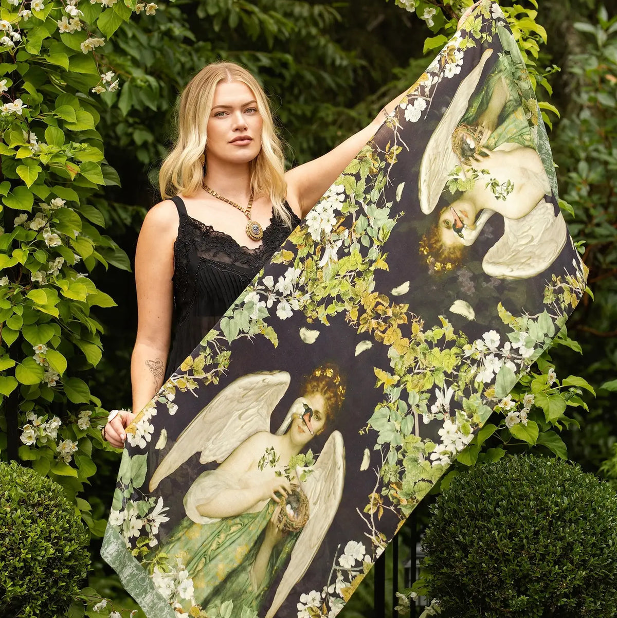 Model holding open the Market of Stars Equinox scarf to show its Pandora, swan and botanical artwork | Bliss by Cori