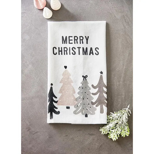 White cotton Merry Christmas tea towel with black, blush and gray Christmas tree forest design styled on a gray surface with frosted pine sprig and pink ornaments – Bliss by Cori
