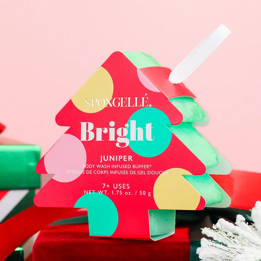 Spongellé Bright Juniper holiday tree body buffer in festive scene with wrapped gifts and holiday decor — Bliss by Cori Boutique