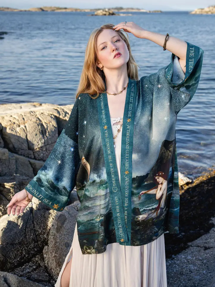 Front view of the Siren mid-length duster styled over a light dress on shoreline rocks | Bliss by Cori