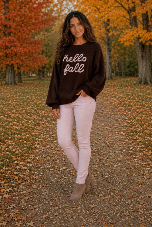"Hello Fall" oversized dark brown sweater with script lettering, styled with blush jeans and tan booties in an autumn park setting | Bliss by Cori Boutique