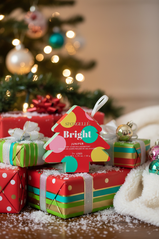 Spongellé Bright Juniper holiday tree body buffer in festive lifestyle scene with wrapped gifts and holiday decor — Bliss by Cori Boutique